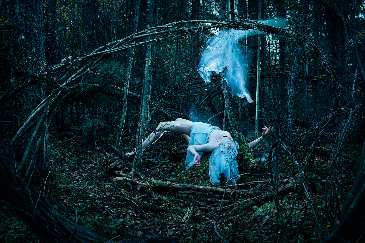 Conceptual fine art photography cinematic tableaux of female figure writhing in tangled woods as her soul escapes her body by Johannesburg photographer Natalie Field in Finalnd at the Arteles Creative Center
